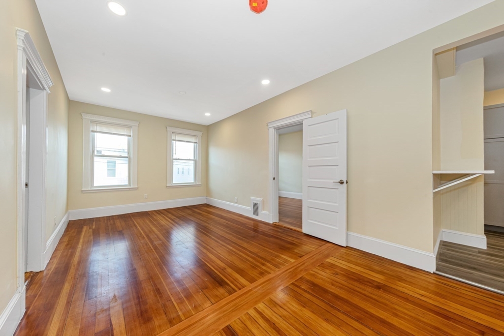 44 Brackett Street, Unit 3 Boston, MA 02135 - Photo 2 of 28 a view of an empty room with wooden floor and a window