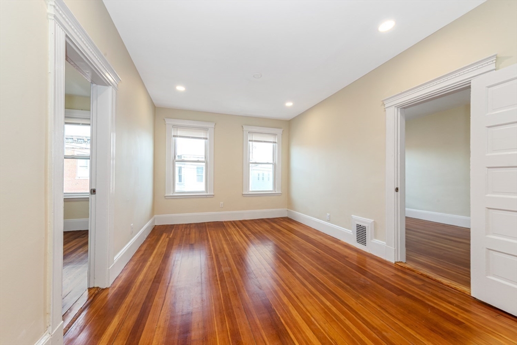 44 Brackett Street, Unit 3 Boston, MA 02135 - Photo 3 of 28 a view of an empty room with wooden floor and a window