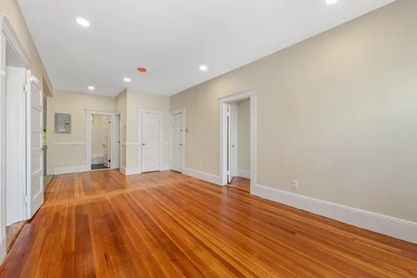 a view of an empty room with wooden floor