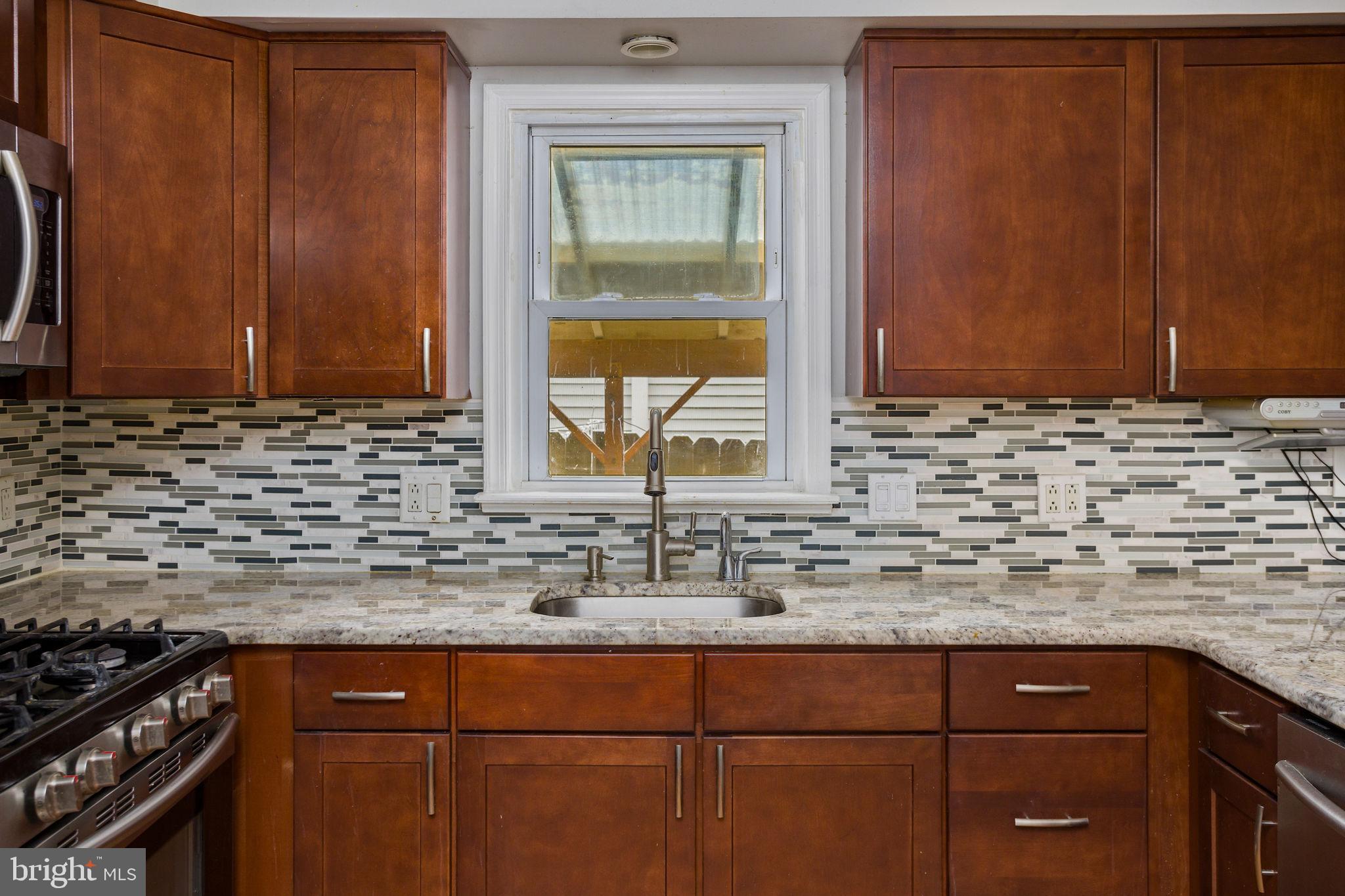 400 Reading Avenue Barrington, NJ 08007 - Photo 12 of 35 a kitchen with granite countertop cabinets sink and window