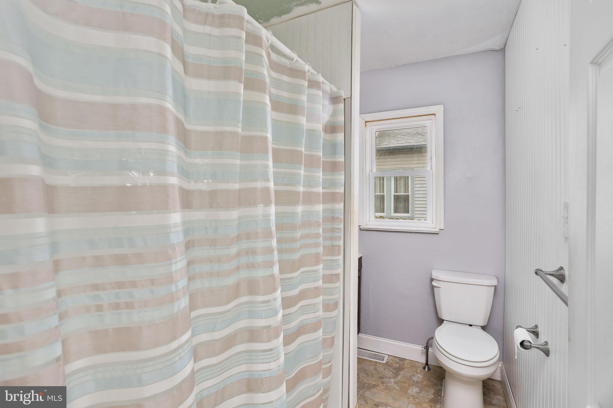 400 Reading Avenue Barrington, NJ 08007 - Photo 27 of 35 a white toilet sitting next to a shower curtain
