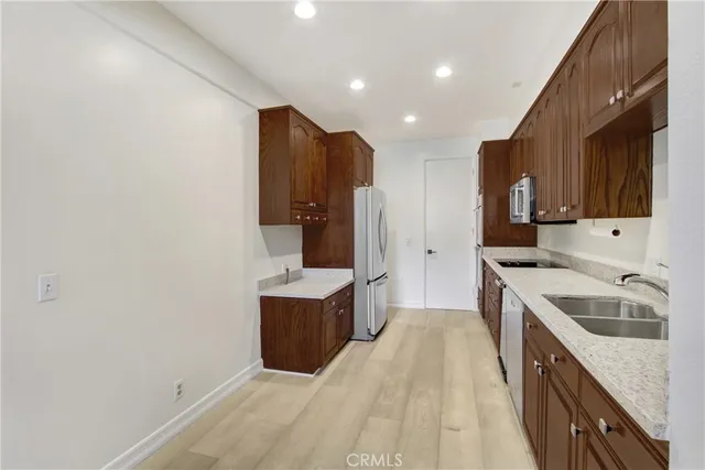 a kitchen with granite countertop a sink stove and refrigerator