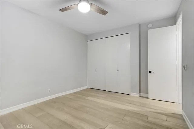 a bedroom with a bed and a lamp on dresser