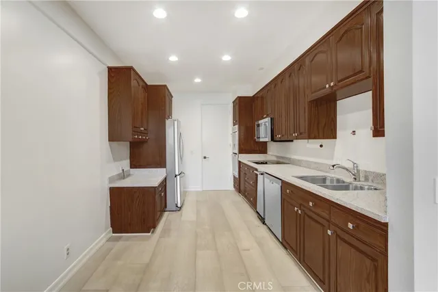 a large kitchen with granite countertop a sink and cabinets
