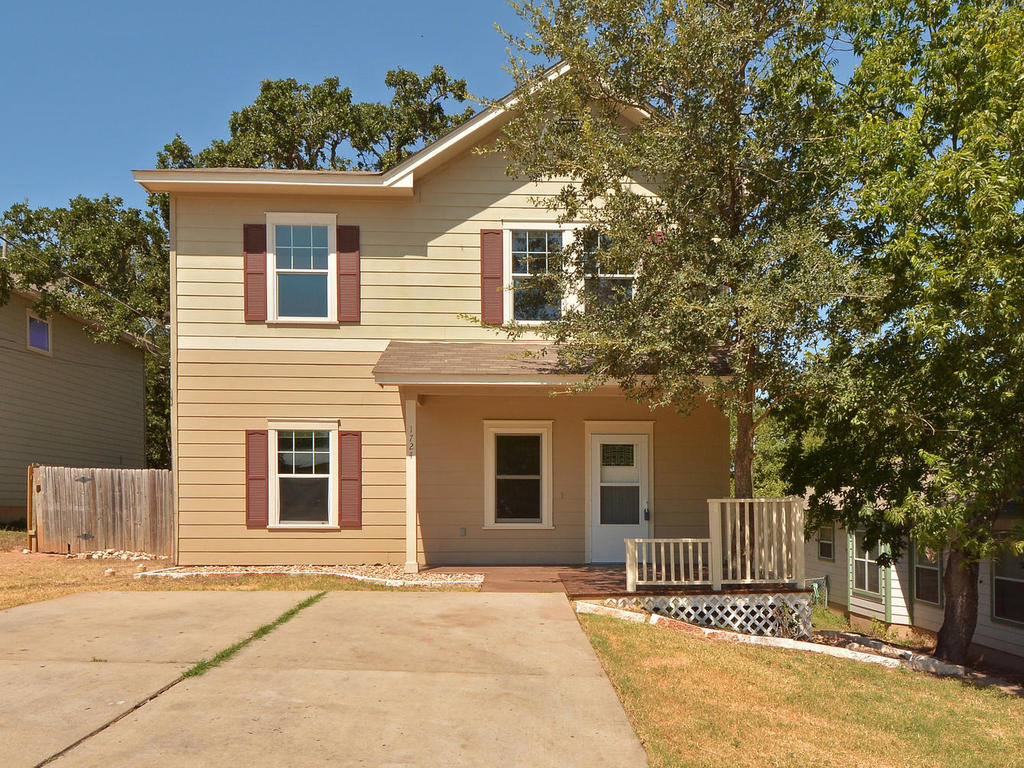 a front view of a house with a tree