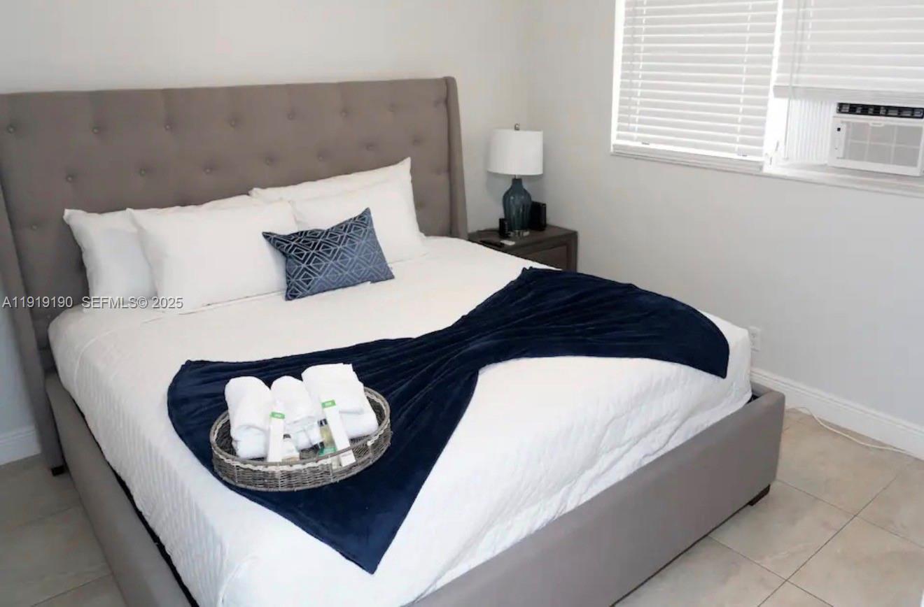 6512 Southwest 24th Street, Unit 1 Miramar, FL 33023 - Photo 11 of 15 a bedroom with a bed and a night stand