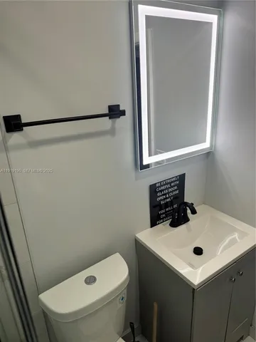 a bathroom with a sink a toilet and mirror