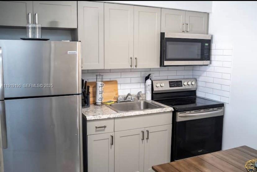 6512 Southwest 24th Street, Unit 1 Miramar, FL 33023 - Photo 3 of 15 a kitchen with stainless steel appliances a refrigerator sink and microwave
