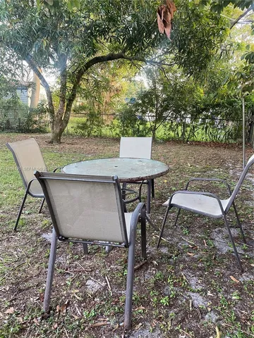 a view of a chairs and table in backyard