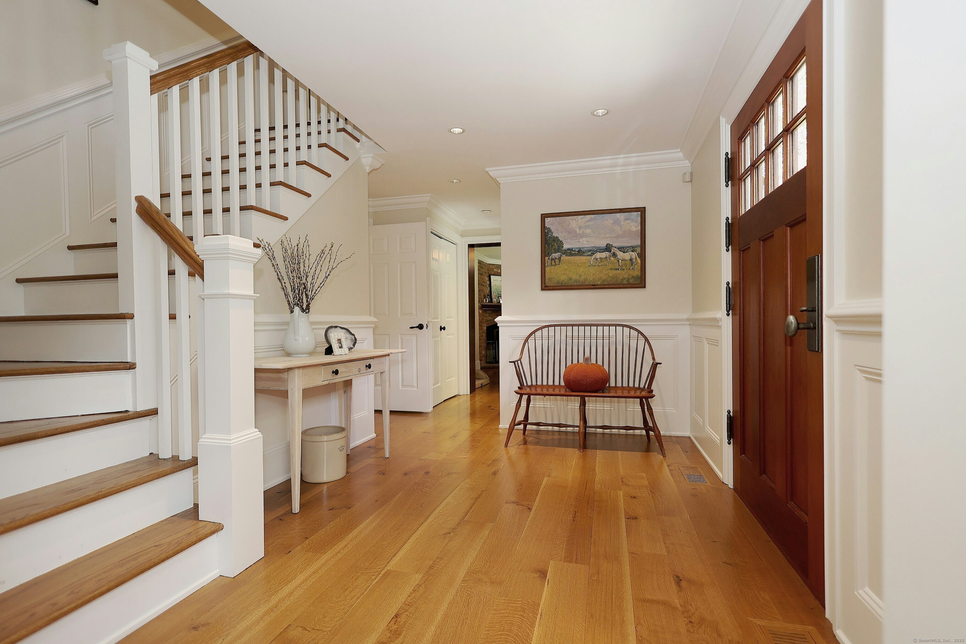 112 Middlebrook Farm Road Wilton, CT 06897 - Photo 11 of 40 a view of a hallway with couches and a dining table with wooden floor