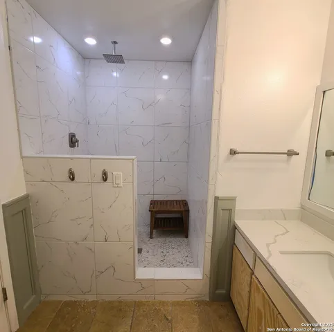 a bathroom with a granite countertop toilet and a sink