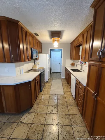 a kitchen with stainless steel appliances granite countertop a sink stove and cabinets