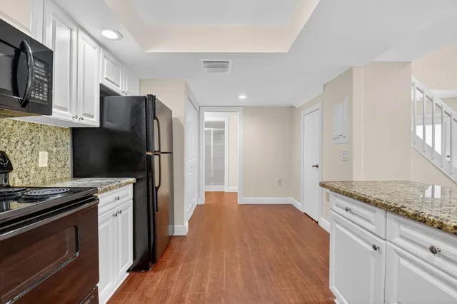 a kitchen with stainless steel appliances granite countertop a refrigerator stove and sink
