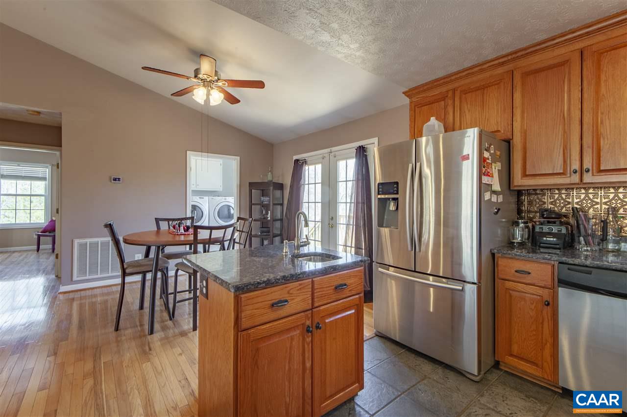 203 Quail Run Amherst, VA 24521 - Photo 18 of 45 a kitchen with stainless steel appliances granite countertop a refrigerator a stove top oven a dining table and chairs with wooden floor