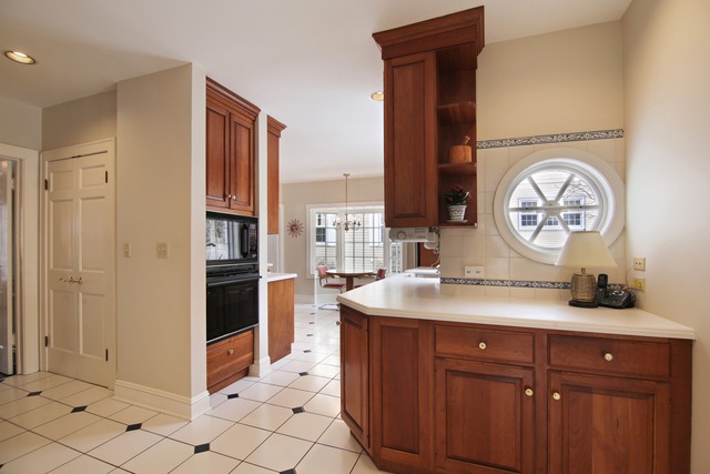 233 Ridge Avenue Winnetka, IL 60093 - Photo 8 of 25 a kitchen with stainless steel appliances granite countertop a sink and a refrigerator