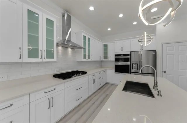 a kitchen with stainless steel appliances granite countertop a sink stove and refrigerator