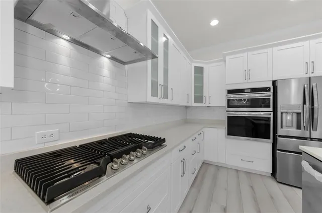 a kitchen with cabinets and wooden floor