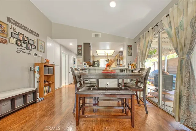 a dining room with wooden floor and large windows