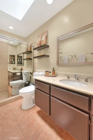 a bathroom with a sink a toilet and a mirror