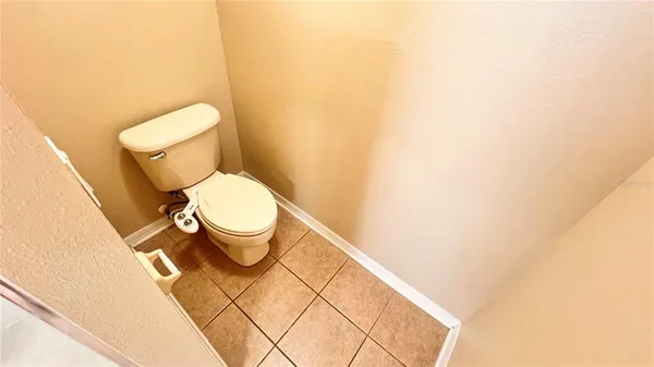 a white toilet sitting next to a white wall