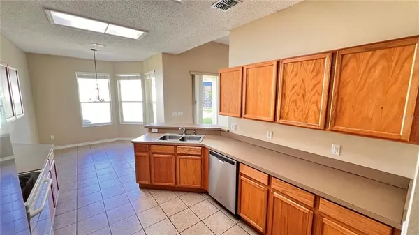 a kitchen with stainless steel appliances a sink window and cabinets