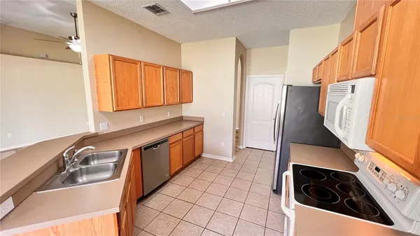 a kitchen with stainless steel appliances a sink a stove a refrigerator and cabinets