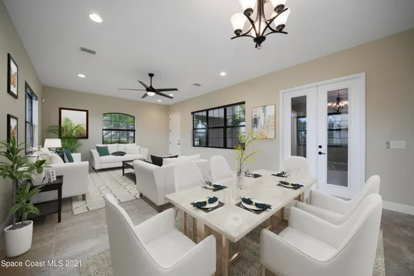 a living room with furniture a chandelier and a table