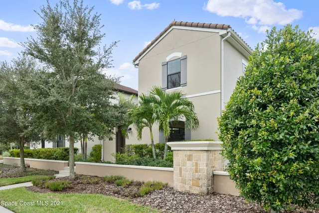 a view of a white house with a yard and plants