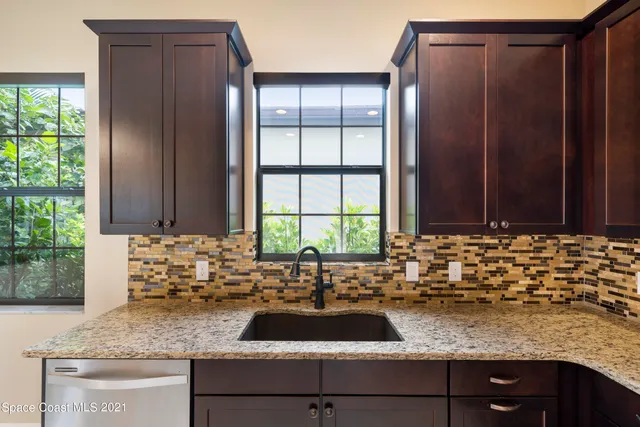 a view of a granite countertop kitchen with a sink and a large window