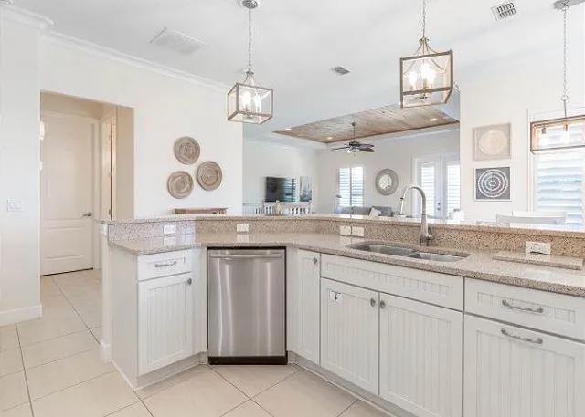 a open kitchen with a sink and dishwasher with white cabinets
