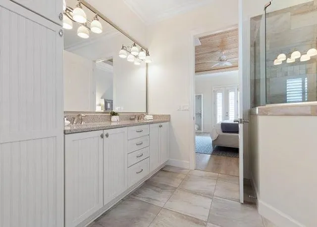 a spacious bathroom with a double vanity sink a mirror and a shower