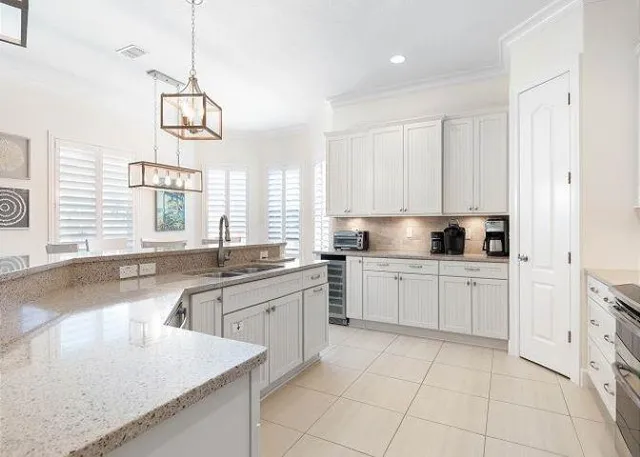 a kitchen with a stove a sink a window and dining table