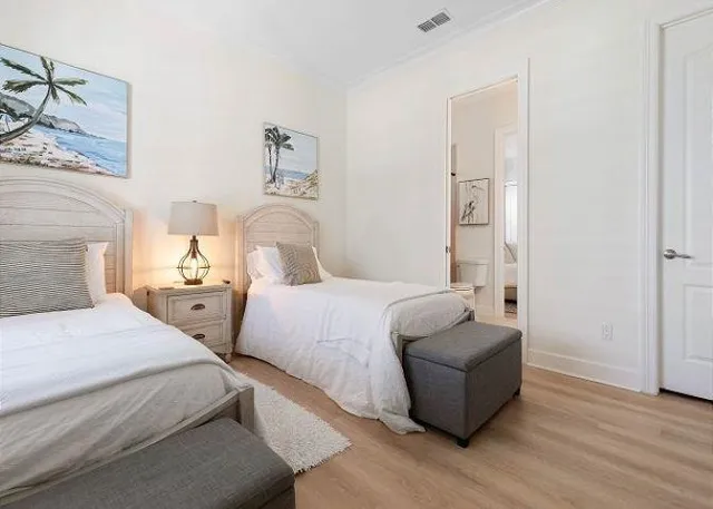 a bedroom with two beds and painting on the wall