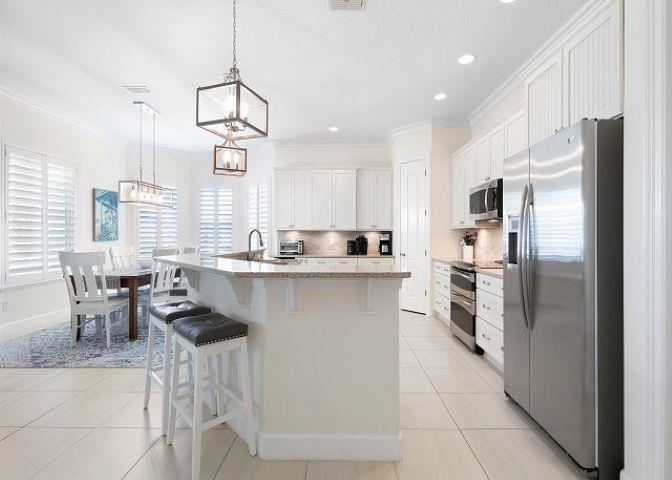 503 Cinnamon Beach Lane Palm Coast, FL 32137 - Photo 5 of 50 a kitchen with stainless steel appliances a refrigerator sink and cabinets