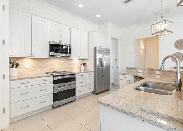 a kitchen with granite countertop a sink and stainless steel appliances