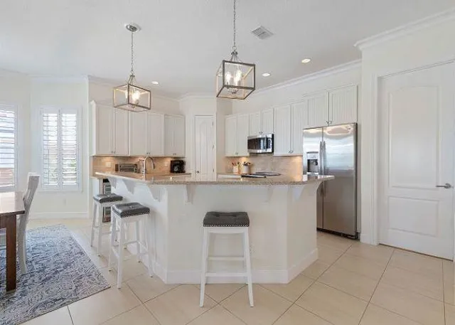 a kitchen with kitchen island granite countertop a counter space a sink appliances and cabinets
