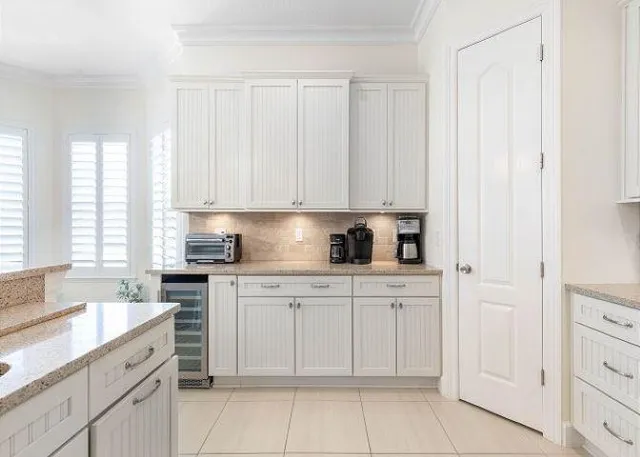 a kitchen with white cabinets and white appliances