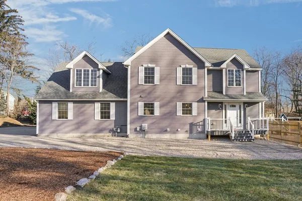 a large kitchen with kitchen island a stove a sink dishwasher a refrigerator and a fireplace with wooden floor