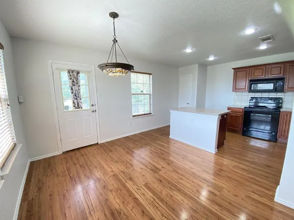 a view of a kitchen with wooden floor and windows