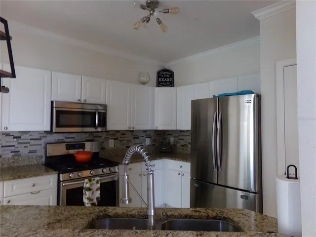 a kitchen with stainless steel appliances granite countertop a stove and a refrigerator