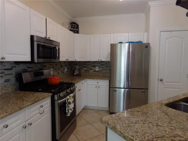 a kitchen with stainless steel appliances granite countertop a refrigerator stove and microwave