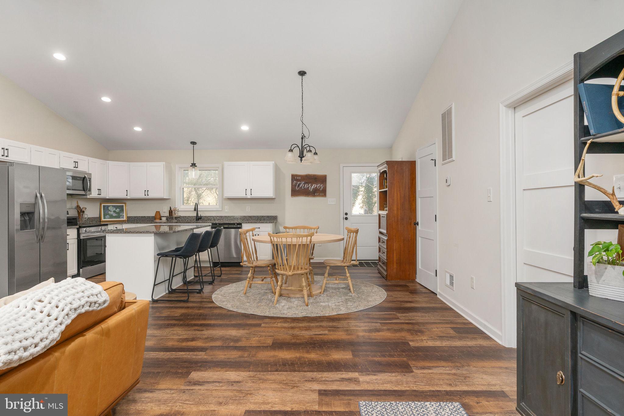 158 Red Hill Road Orange, VA 22960 - Photo 11 of 54 a kitchen with stainless steel appliances kitchen island granite countertop a refrigerator a stove a sink a dining table and chairs with wooden floor