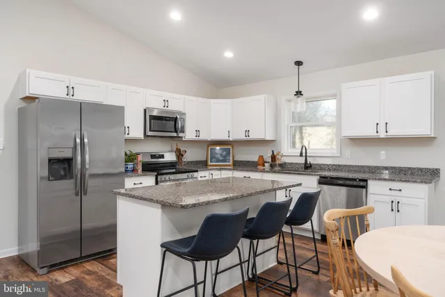 a kitchen with stainless steel appliances granite countertop a stove a microwave and cabinets