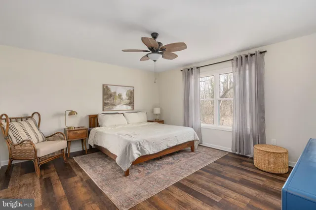 a bedroom with a large bed and a ceiling fan