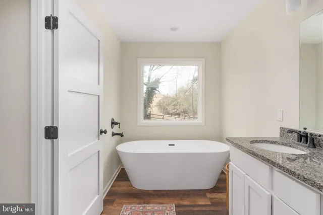a bathroom with a granite countertop sink and a mirror