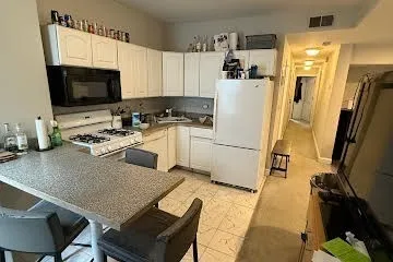 a kitchen with a refrigerator a stove a microwave a sink and cabinets