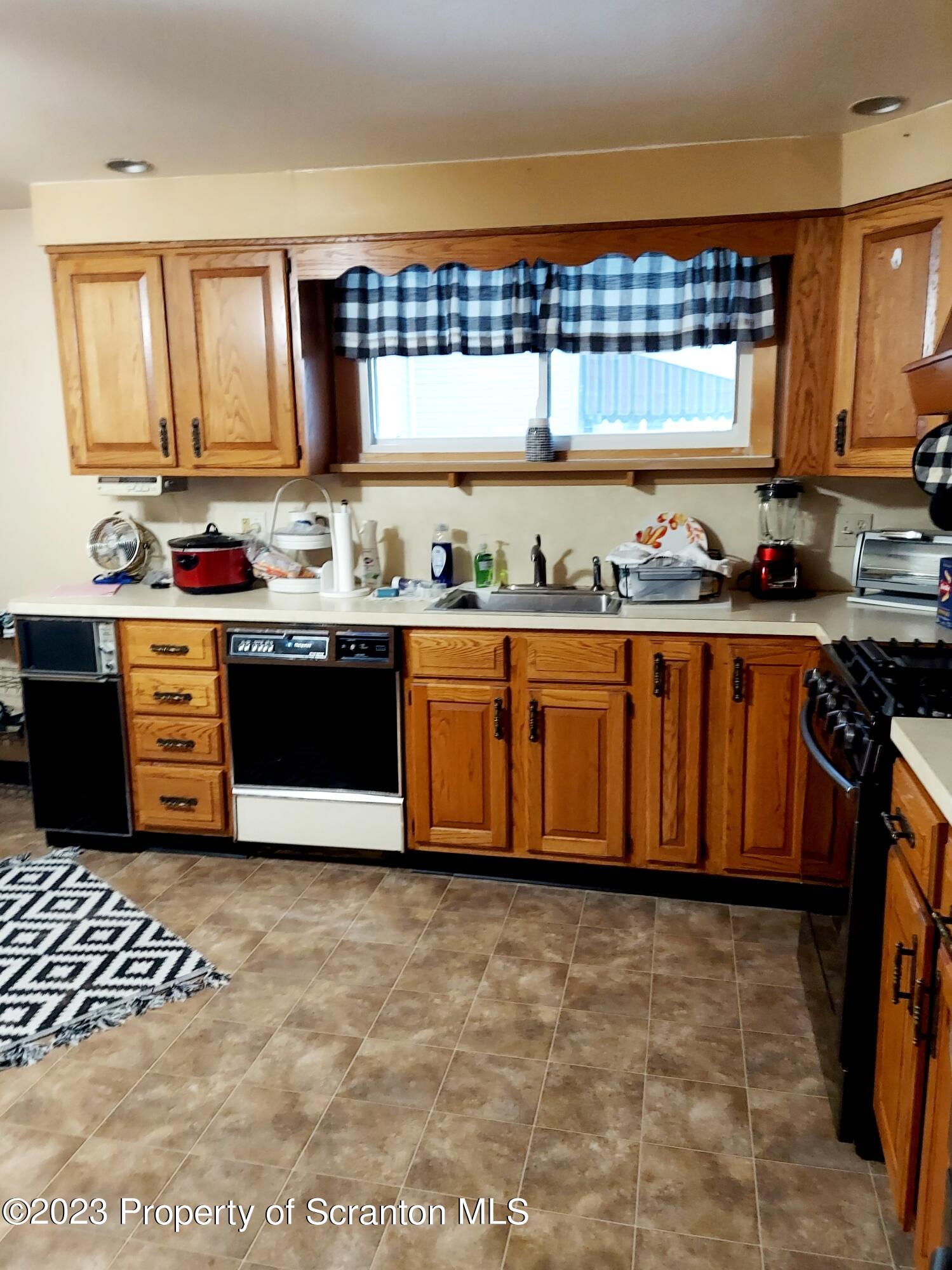214 Cherry Street Dunmore, PA 18512 - Photo 13 of 58 a kitchen with granite countertop a stove a sink dishwasher and cabinets