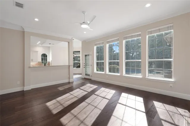 an empty room with windows and chandelier