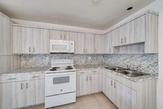 a kitchen with white cabinets sink and white appliances