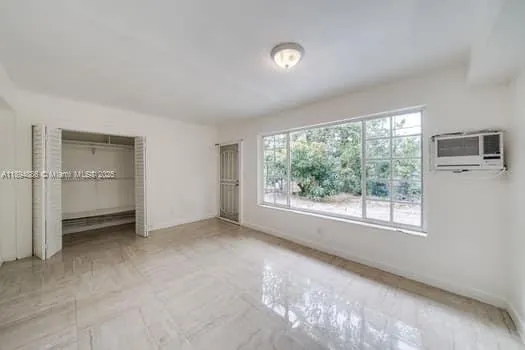 an empty room with windows and closet